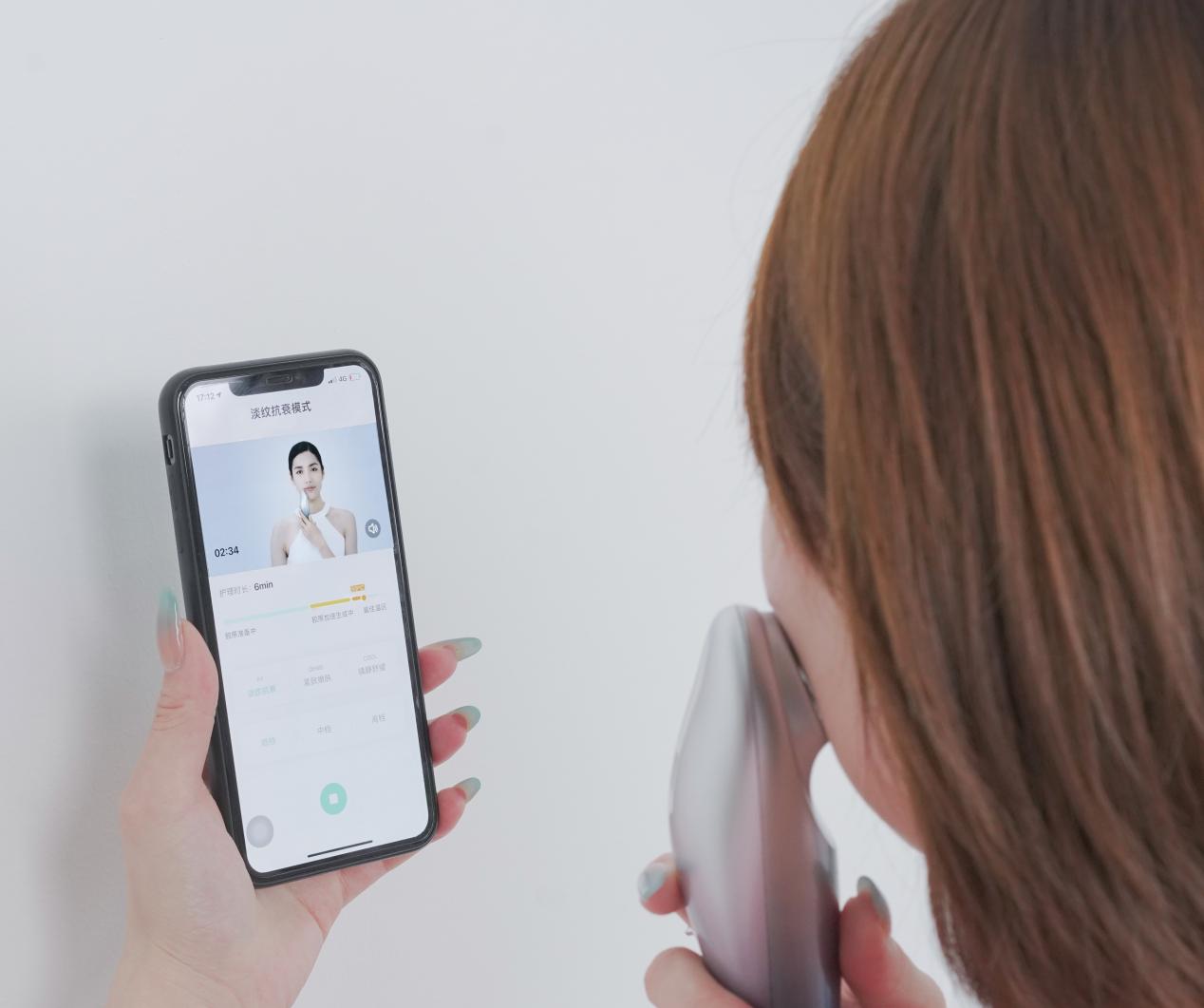 消费者在美丽肌因app的指导下使用智能射频仪护肤
